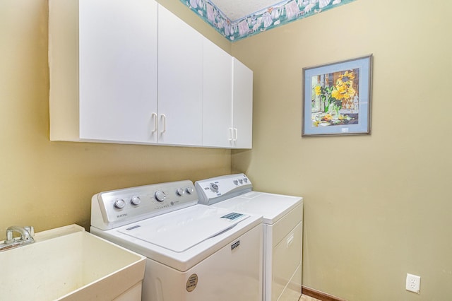 laundry area with cabinet space, washer and dryer, and a sink