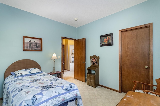 bedroom with baseboards and light colored carpet