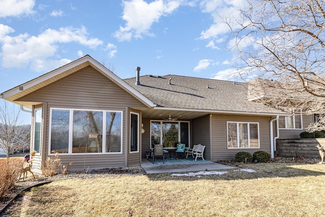 rear view of property with a patio area, a yard, and roof with shingles