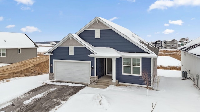 view of front of property with a garage and central AC