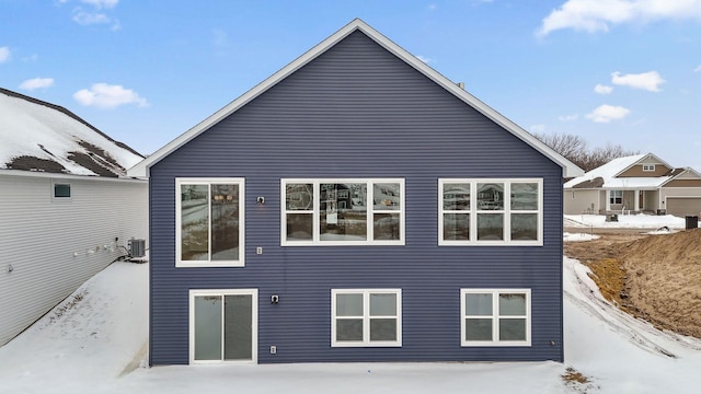 snow covered property with central AC unit