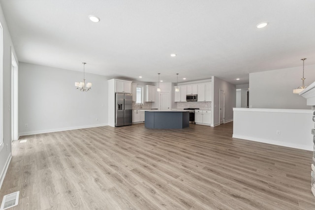 unfurnished living room with recessed lighting, visible vents, a chandelier, light wood-type flooring, and baseboards