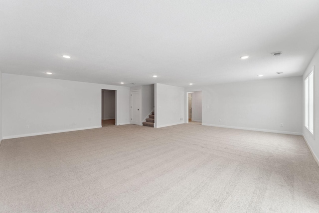 interior space with recessed lighting, baseboards, stairway, and light colored carpet