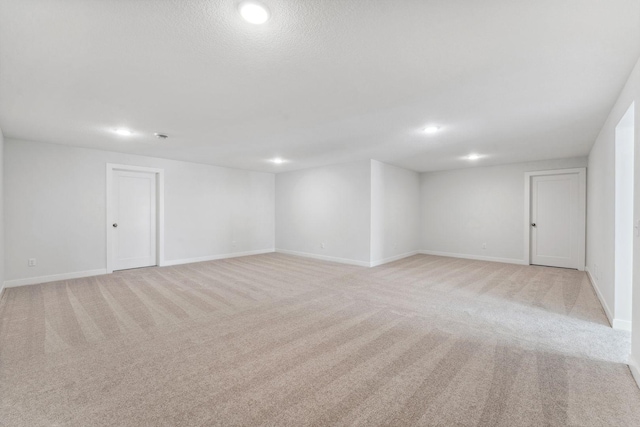 empty room featuring recessed lighting, baseboards, and light colored carpet