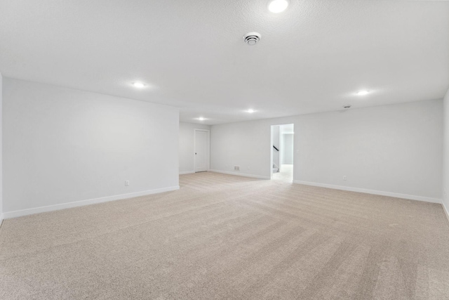 unfurnished room with recessed lighting, light carpet, and baseboards