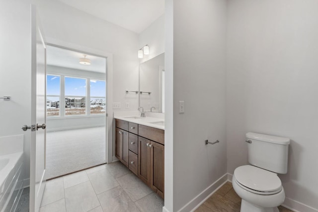 4870 127th Ln NE, Blaine, MN 55449 - full bathroom with toilet, double vanity, a tub, and baseboards