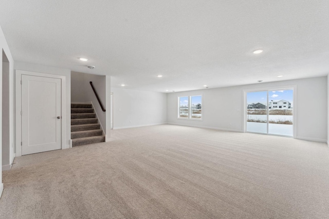 4870 127th Ln NE, Blaine, MN 55449 - unfurnished living room with stairs, carpet, recessed lighting, baseboards, and a textured ceiling
