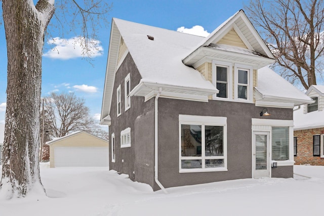 exterior space with an outdoor structure, a detached garage, and stucco siding