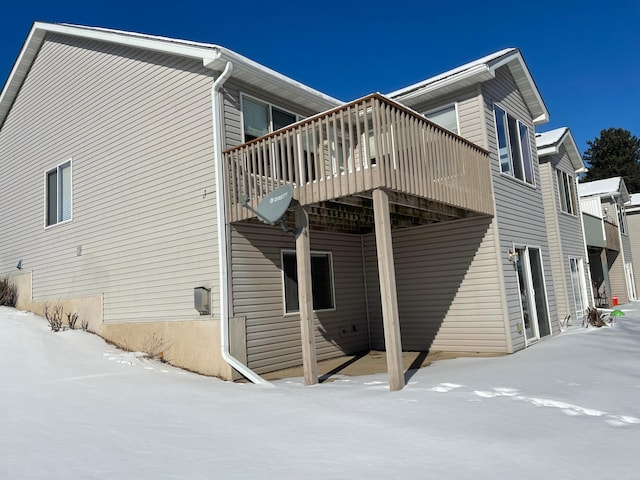 view of snowy exterior with a deck