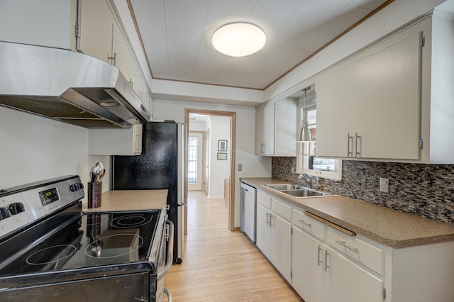 kitchen featuring backsplash, appliances with stainless steel finishes, ornamental molding, a sink, and under cabinet range hood