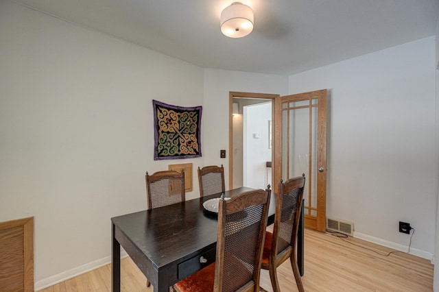 dining room featuring light wood-type flooring, baseboards, and visible vents