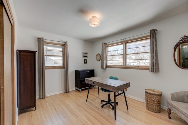 office area featuring light wood-style floors, a healthy amount of sunlight, and baseboards