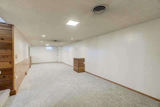 basement featuring carpet, visible vents, and baseboards