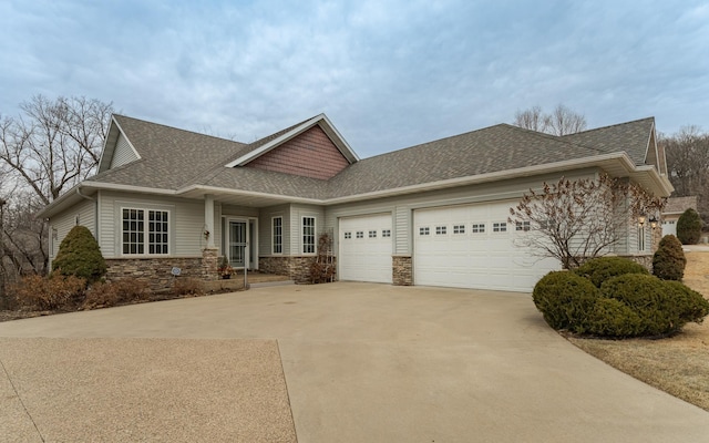 view of front of property with stone siding, a shingled roof, an attached garage, and driveway