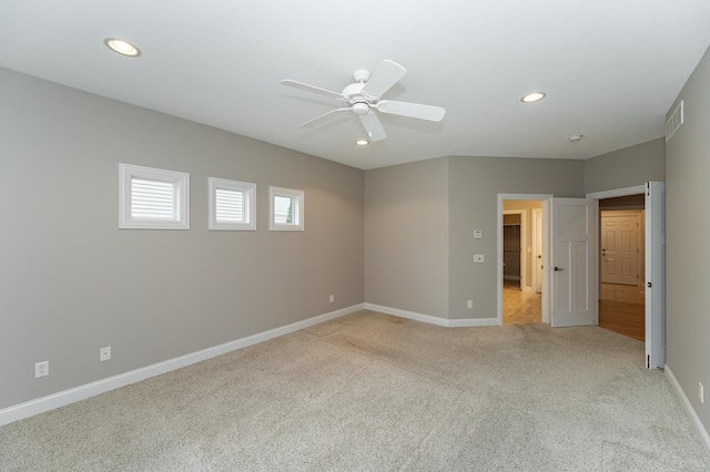 empty room featuring baseboards, light carpet, visible vents, and recessed lighting