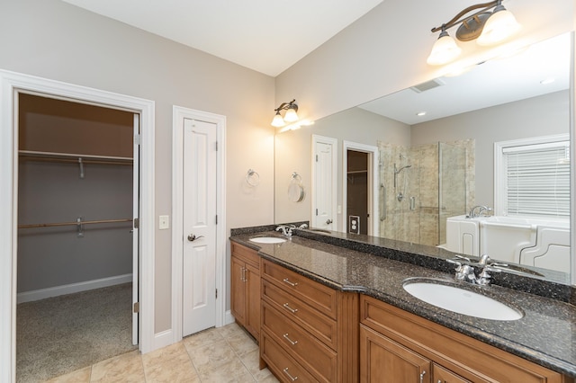 full bath with double vanity, a stall shower, visible vents, a spacious closet, and a sink