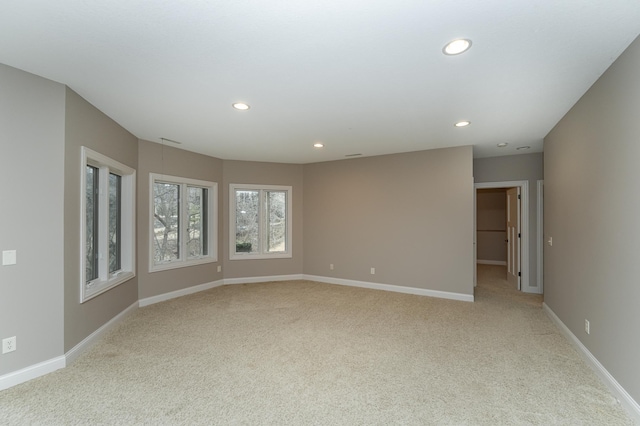 spare room with light carpet, baseboards, and recessed lighting