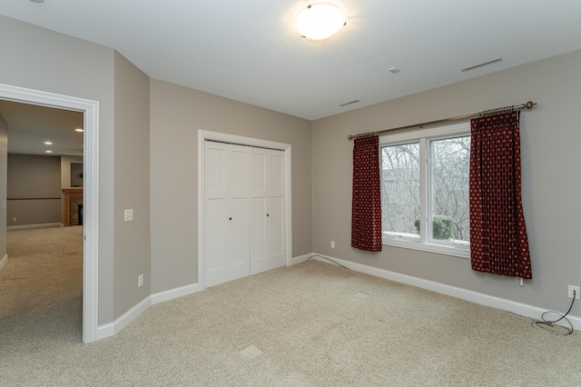 unfurnished bedroom featuring a fireplace, carpet flooring, visible vents, and baseboards