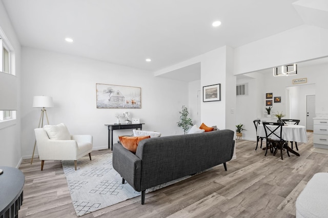 living room with baseboards, light wood-style flooring, and recessed lighting