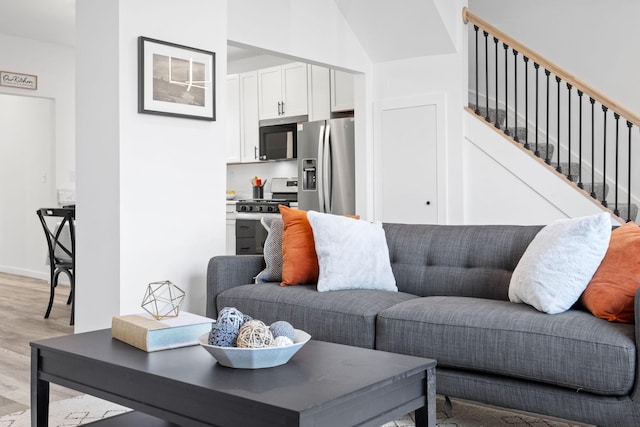 living room with stairs and light wood-style flooring