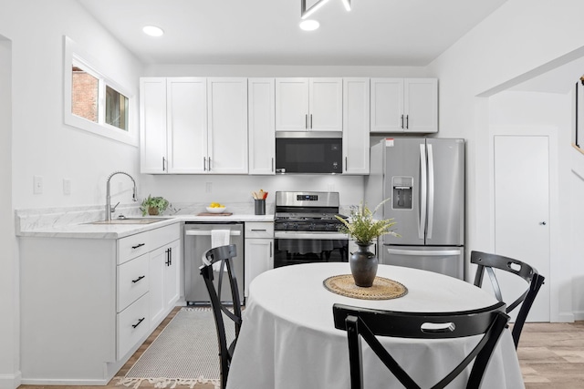 kitchen featuring white cabinets, stainless steel appliances, and a sink