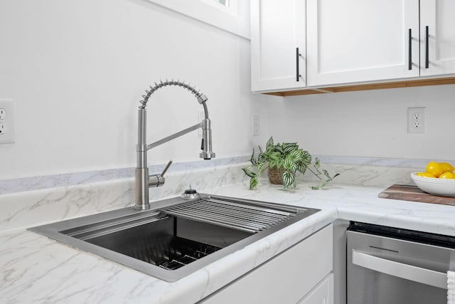 details featuring dishwasher, light stone counters, white cabinets, and a sink