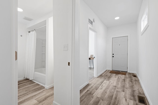 corridor with light wood-style floors, baseboards, visible vents, and recessed lighting