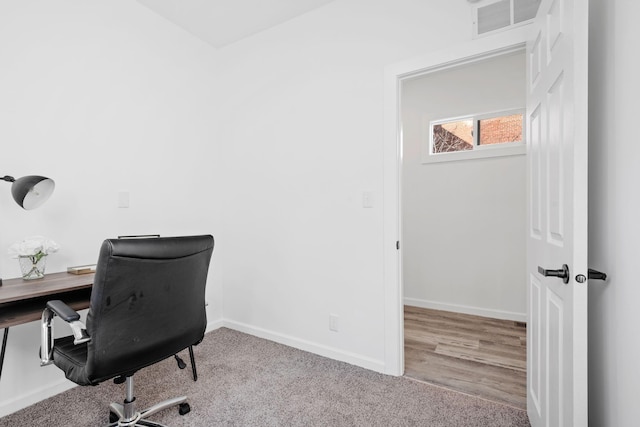 home office featuring light carpet, visible vents, and baseboards