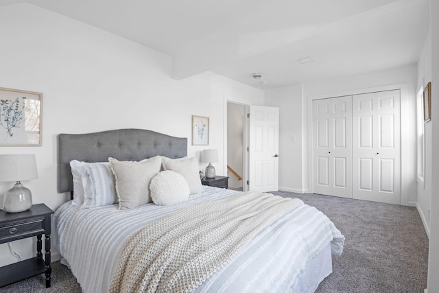 carpeted bedroom with a closet and baseboards