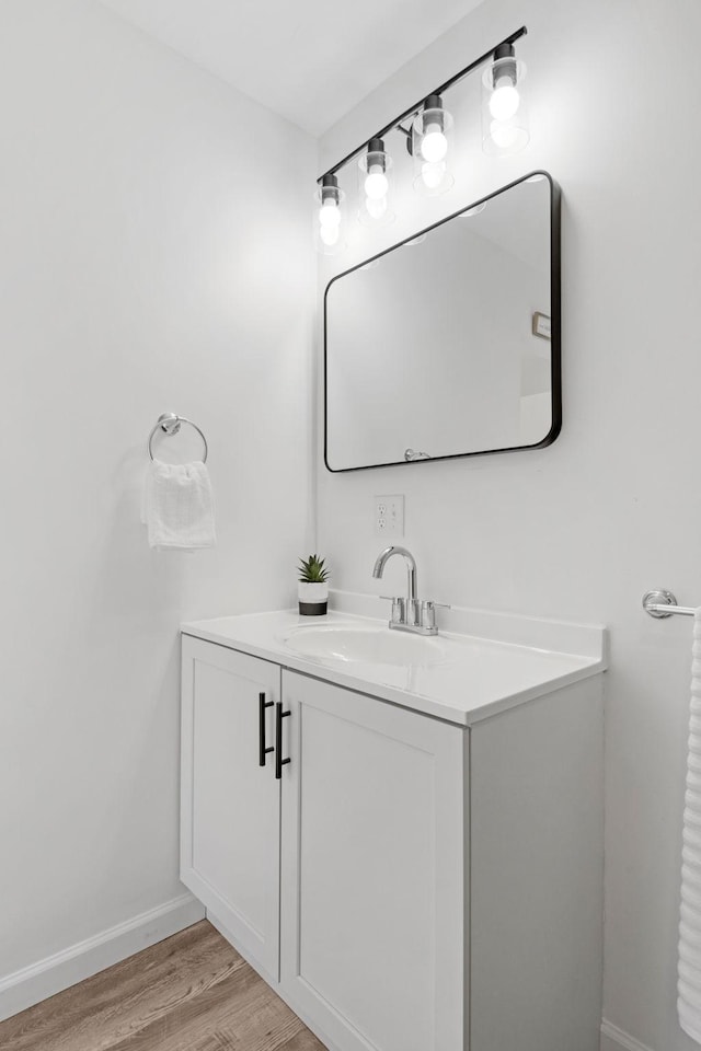 bathroom with vanity, baseboards, and wood finished floors