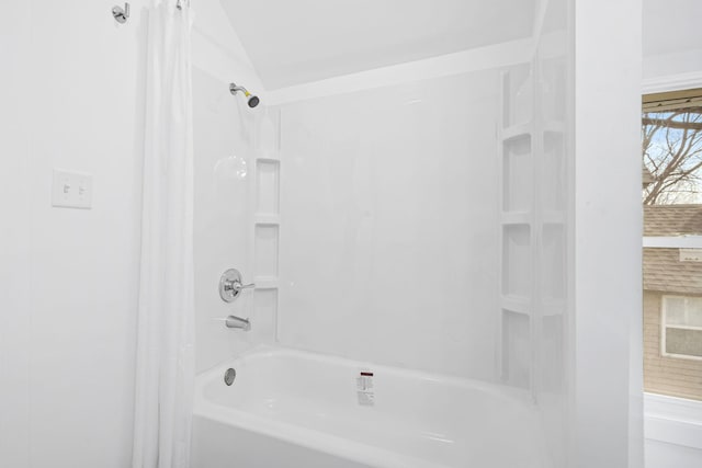 bathroom featuring lofted ceiling and shower / bath combo