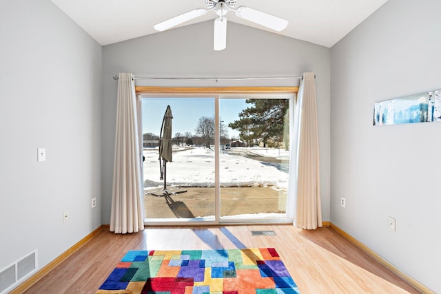 interior space with lofted ceiling, baseboards, visible vents, and wood finished floors