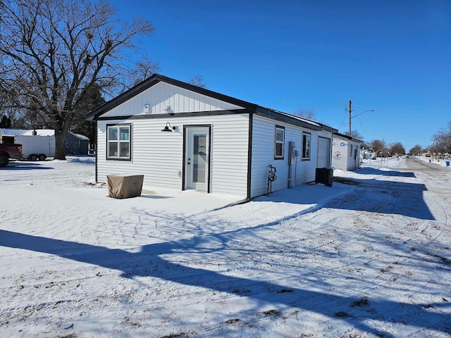 view of snow covered back of property