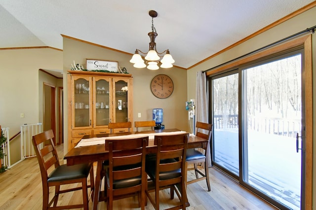 19241 Ebony Rd, Osakis, MN 56360 - dining room featuring crown molding, light wood-style floors, vaulted ceiling, and a chandelier
