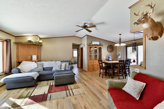 19241 Ebony Rd, Osakis, MN 56360 - living area featuring light wood-style flooring, a ceiling fan, a chandelier, vaulted ceiling, and ornamental molding