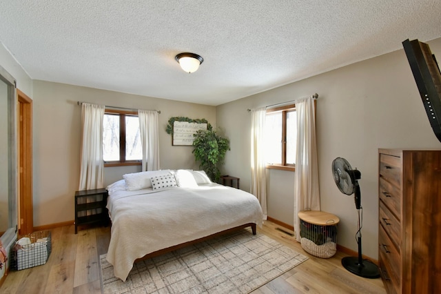 19241 Ebony Rd, Osakis, MN 56360 - bedroom featuring a textured ceiling, light wood-style floors, and baseboards