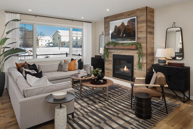 living area featuring a premium fireplace, wood finished floors, and recessed lighting