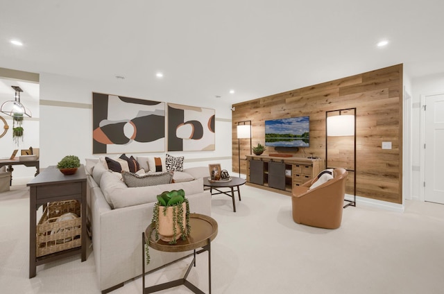 living room featuring light carpet, wooden walls, and recessed lighting