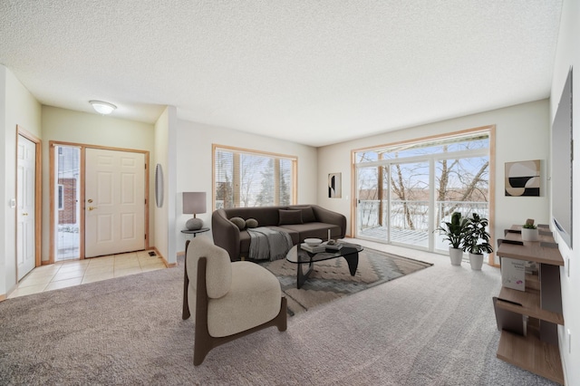 living room featuring light carpet, a textured ceiling, and light tile patterned floors