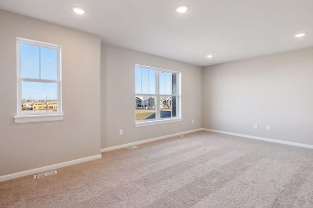 carpeted spare room with baseboards, visible vents, and recessed lighting