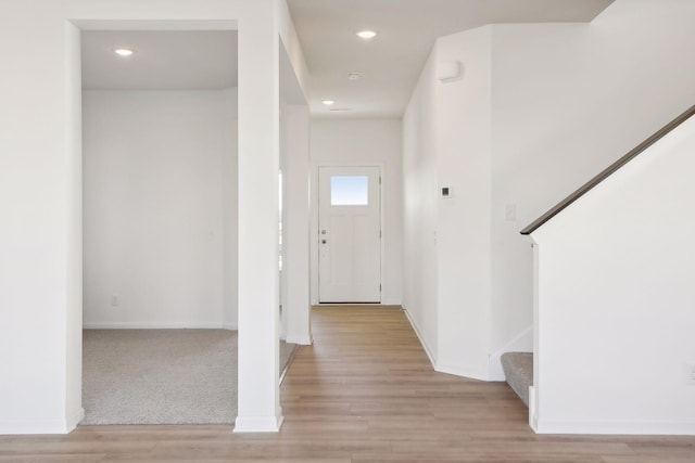 foyer featuring light wood-type flooring, stairway, baseboards, and recessed lighting