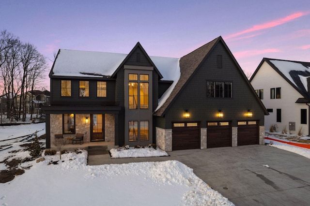 view of front of house with a garage, stone siding, and driveway