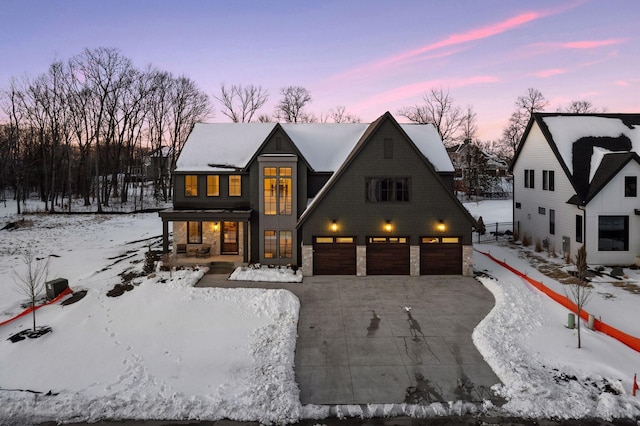 view of front of property with an attached garage, concrete driveway, and stone siding