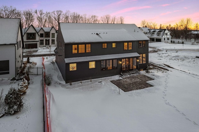 view of snow covered rear of property