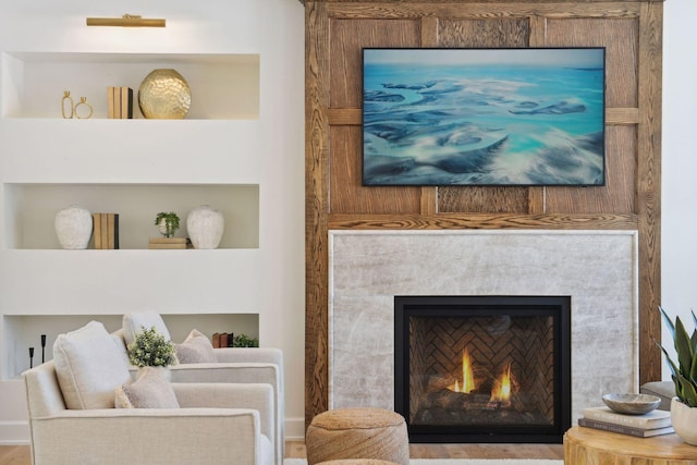 interior space featuring a warm lit fireplace and built in features