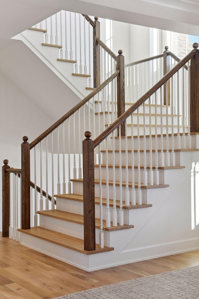 staircase featuring baseboards and wood finished floors