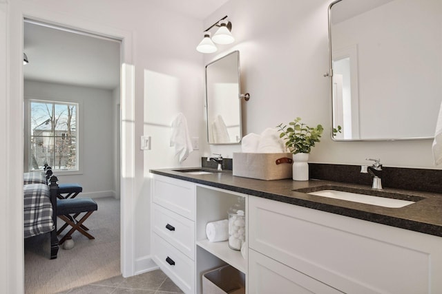 ensuite bathroom featuring ensuite bathroom, double vanity, a sink, and tile patterned floors