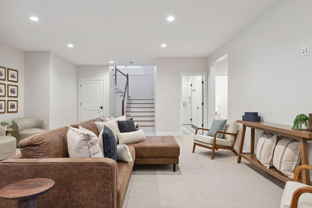 living area featuring light carpet, baseboards, stairway, and recessed lighting