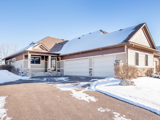 view of front facade with an attached garage and stone siding