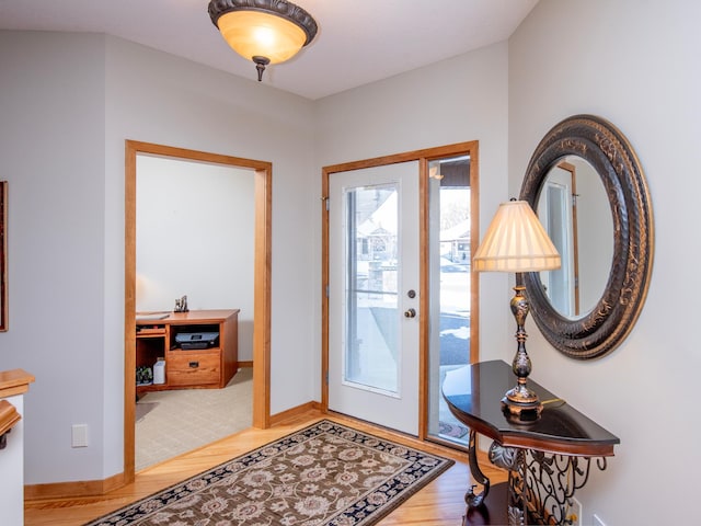 foyer with baseboards and wood finished floors